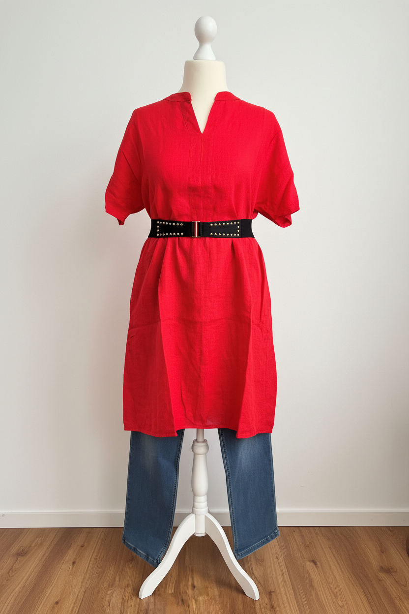 Rotes Kleid mit Gürtel vor weißer Wand